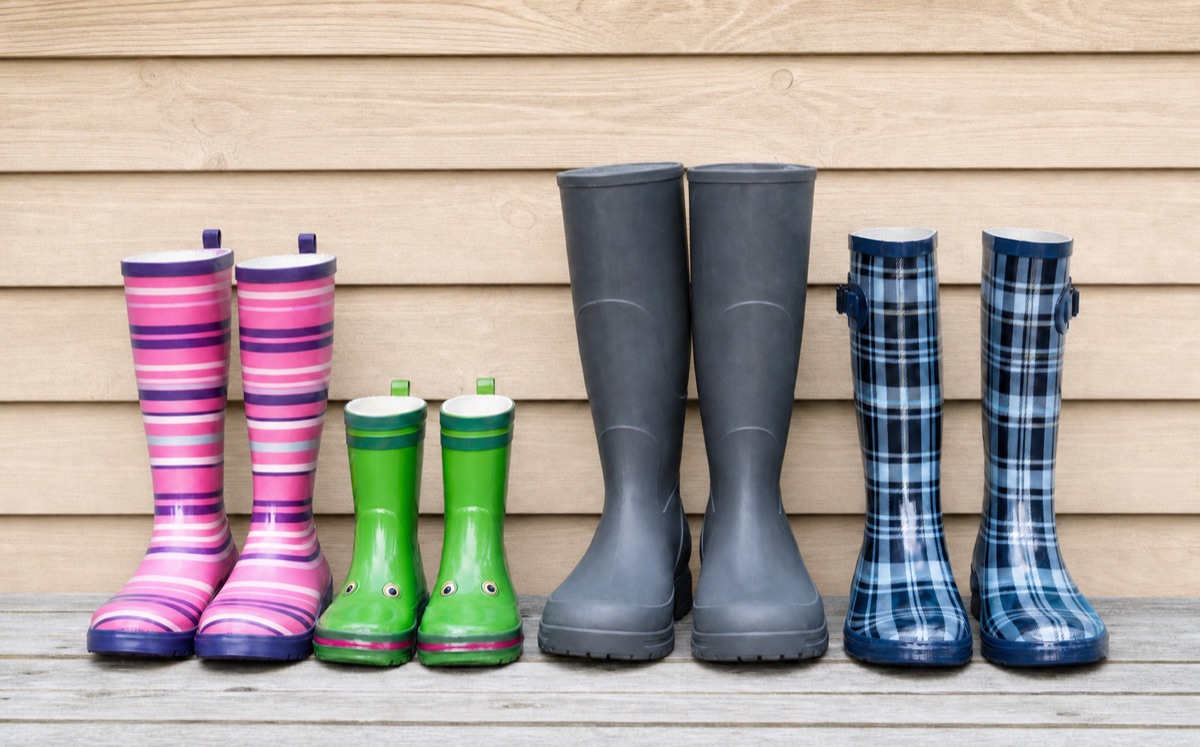 Gummistiefel vor einer Bretterwand